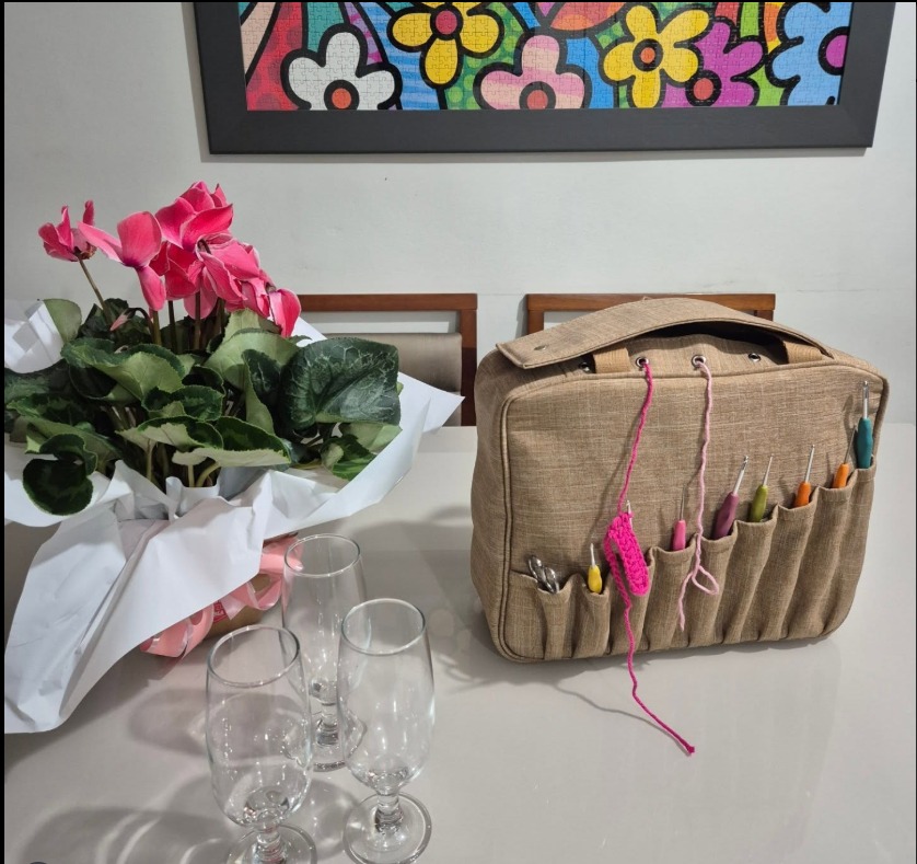 Foto da artesã trabalhando em sua máquina de costura em um ateliê bem iluminado.